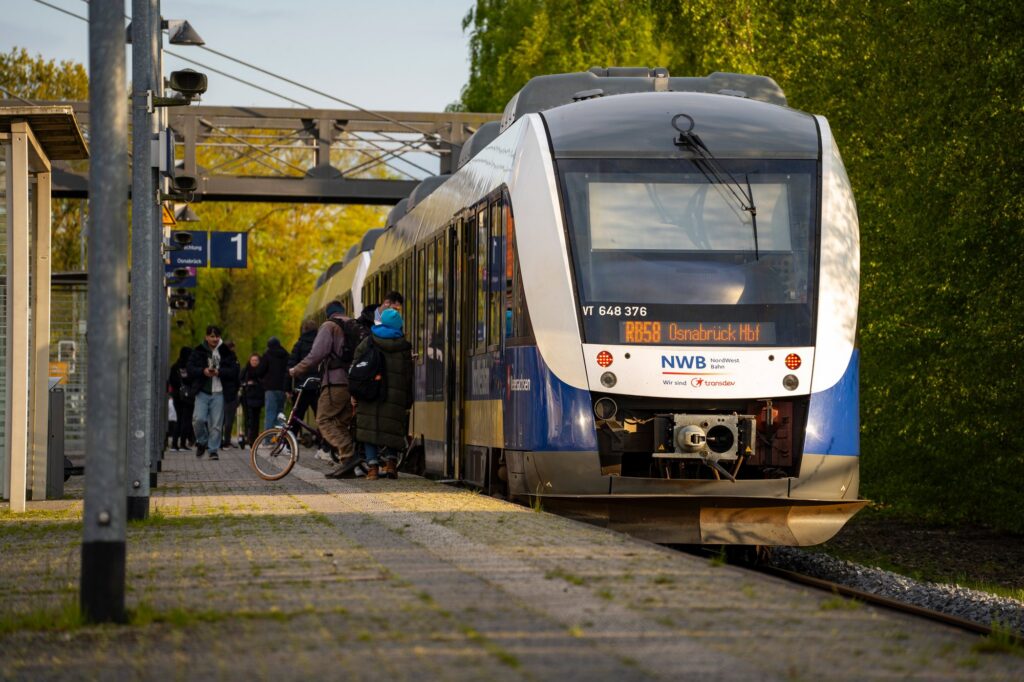 LINT-Triebzug der NordWestBahn mit Fahrgästen am Bahnsteig