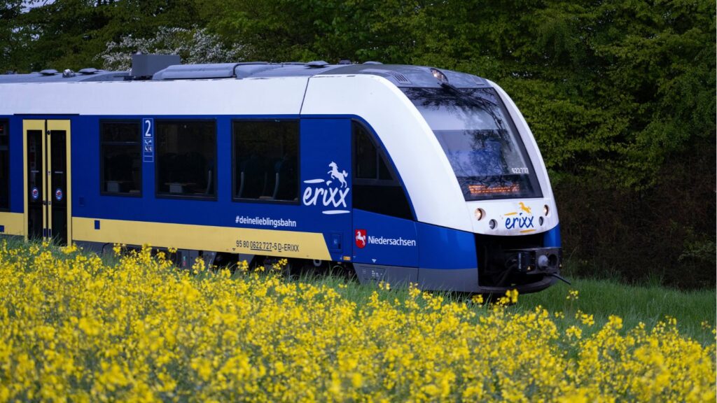 LINT-Triebzug der LNVG im erixx-Design fährt an einem Rapsfeld vorbei